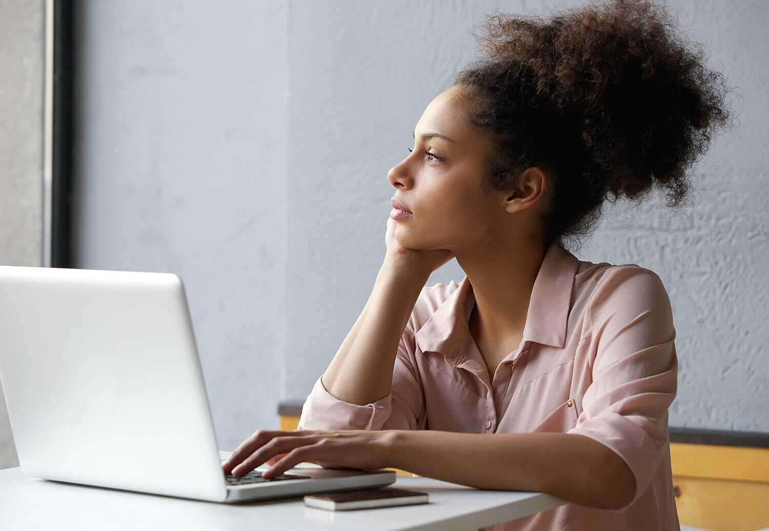 woman daydreaming while working on computer